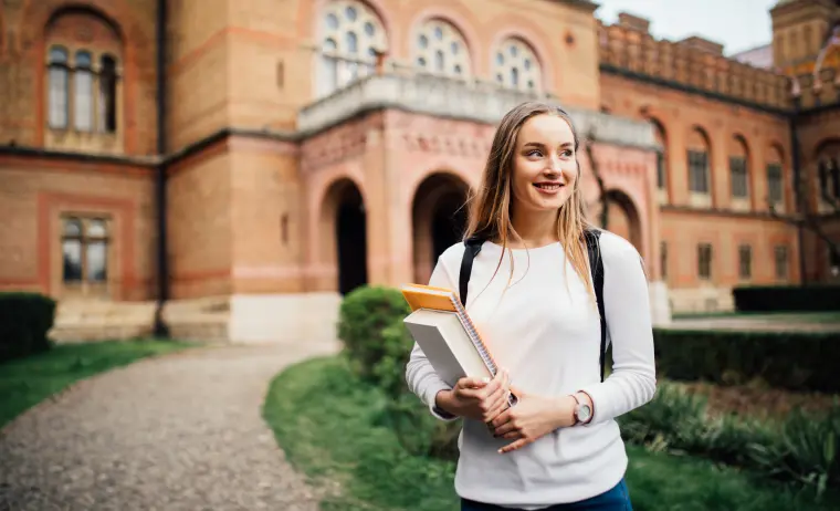 IELTS student stands in front of a university